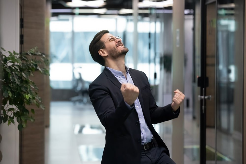 Millennial,Office,Worker,In,Suit,Standing,In,Hallway,Clenched,Fists