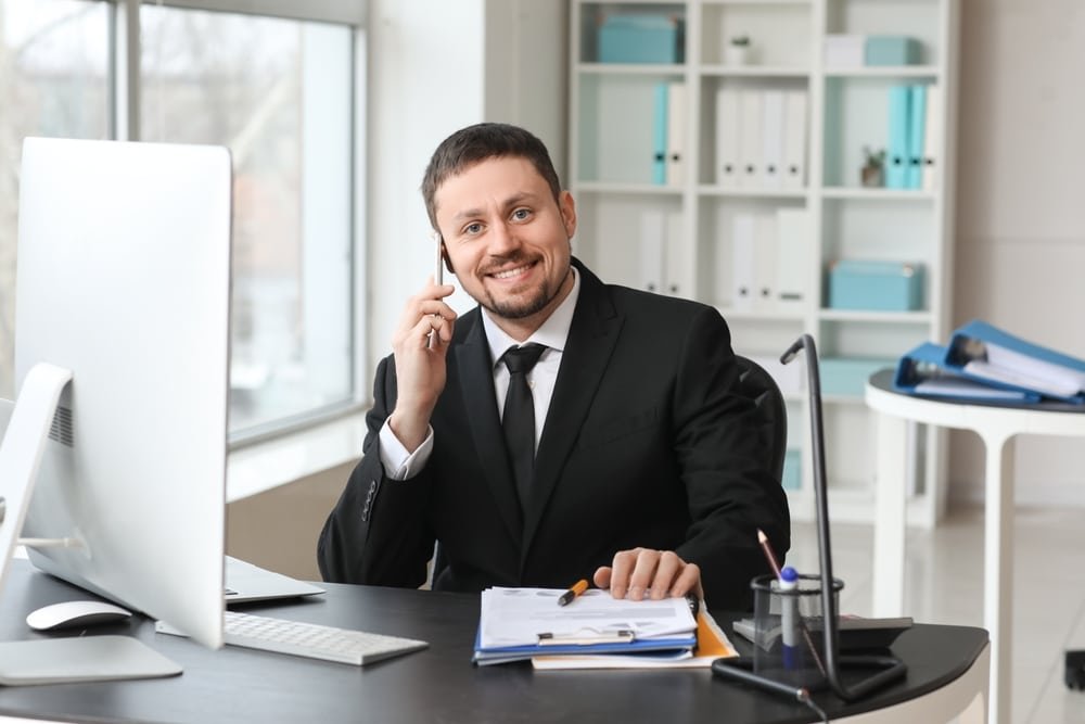 Male,Accountant,Talking,By,Mobile,Phone,At,Table,In,Office