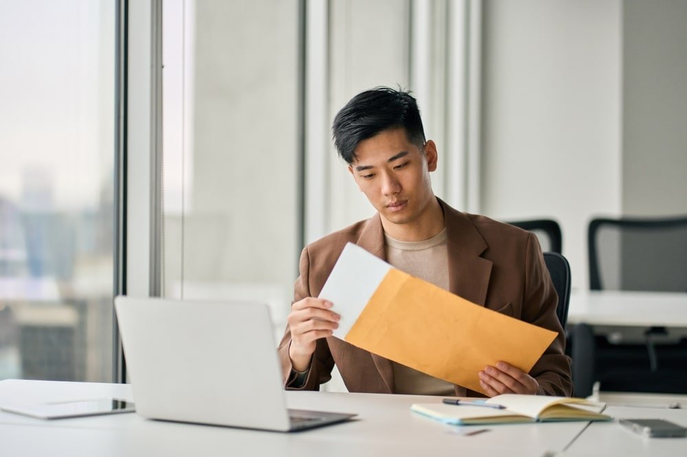 Young,Busy,Asian,Professional,Business,Man,Manager,Opening,Envelope,Delivery