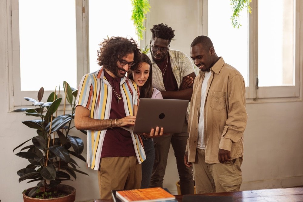 Multiracial,Coworkers,Gathered,Around,The,Laptop,,Engrossed,In,The,Complexities