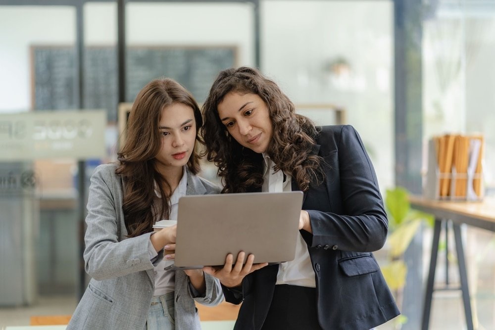 Young,Businesswoman,And,Accountant,Talking,With,Laptop,And,Tablet,Two