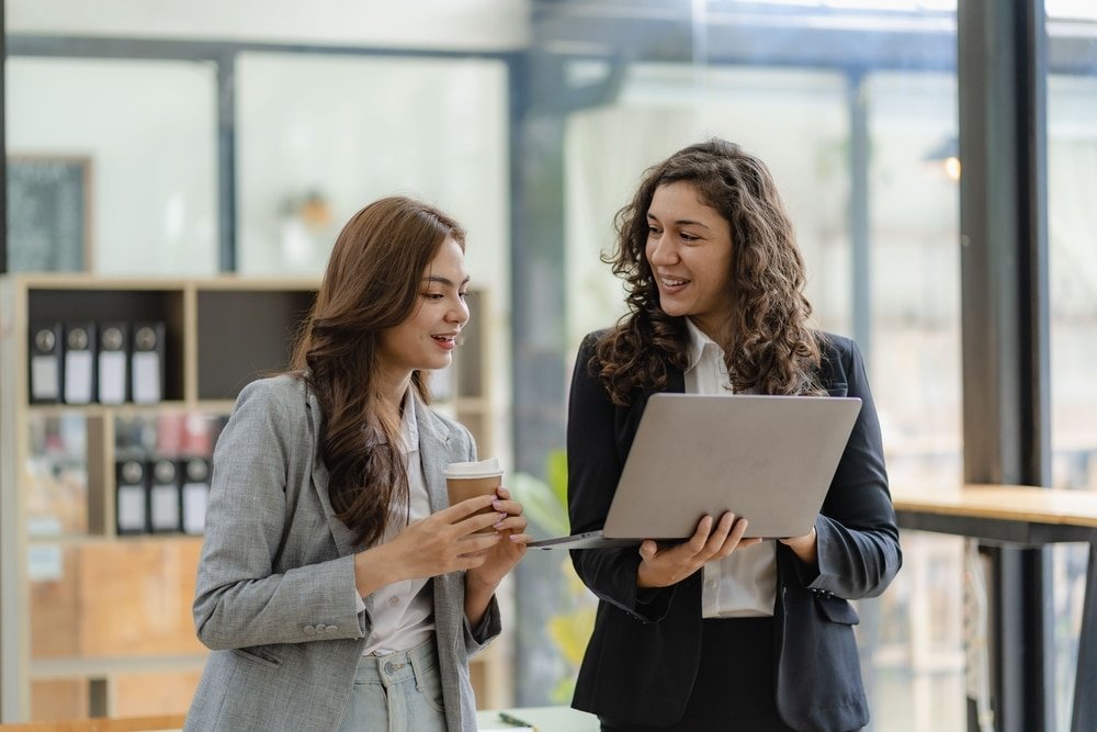 Young,Businesswoman,And,Accountant,Talking,With,Laptop,And,Tablet,Two