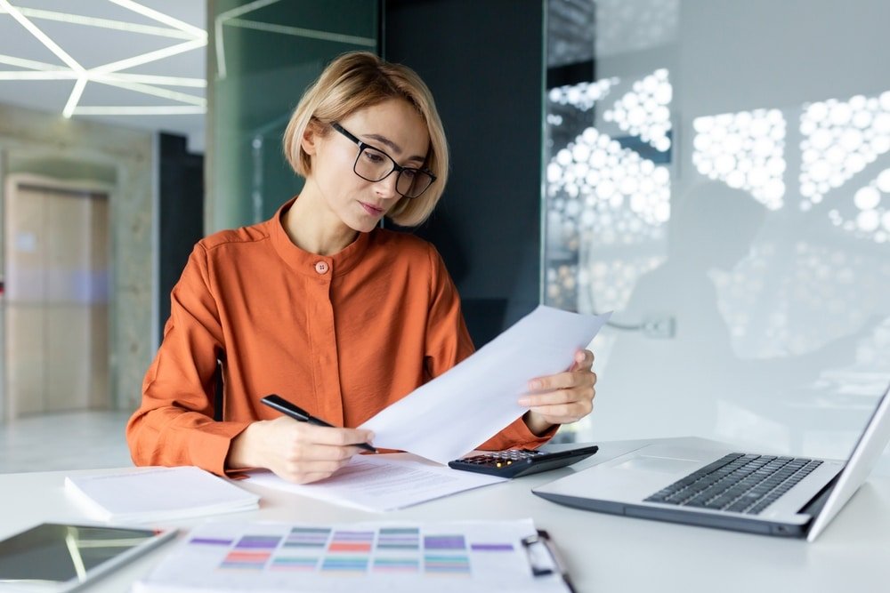 Serious,And,Pensive,Business,Woman,Behind,Paper,Work,Inside,Office,