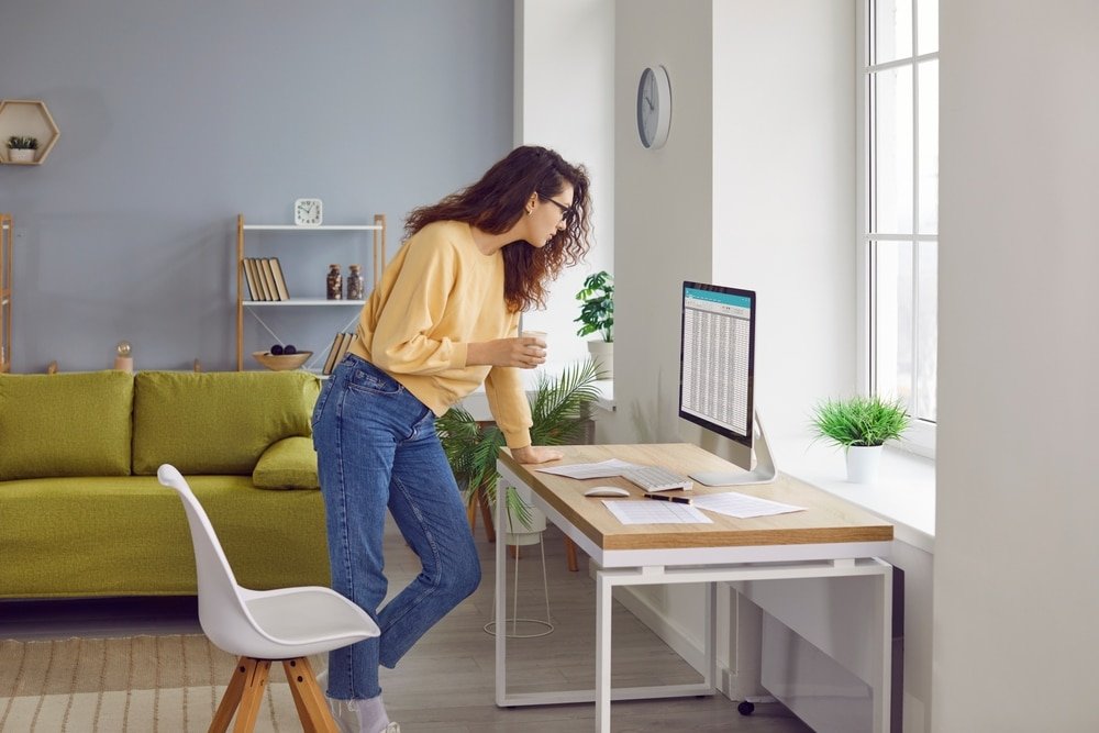 Young,Woman,Accountant,Working,From,Home,,Standing,By,Her,Desk,