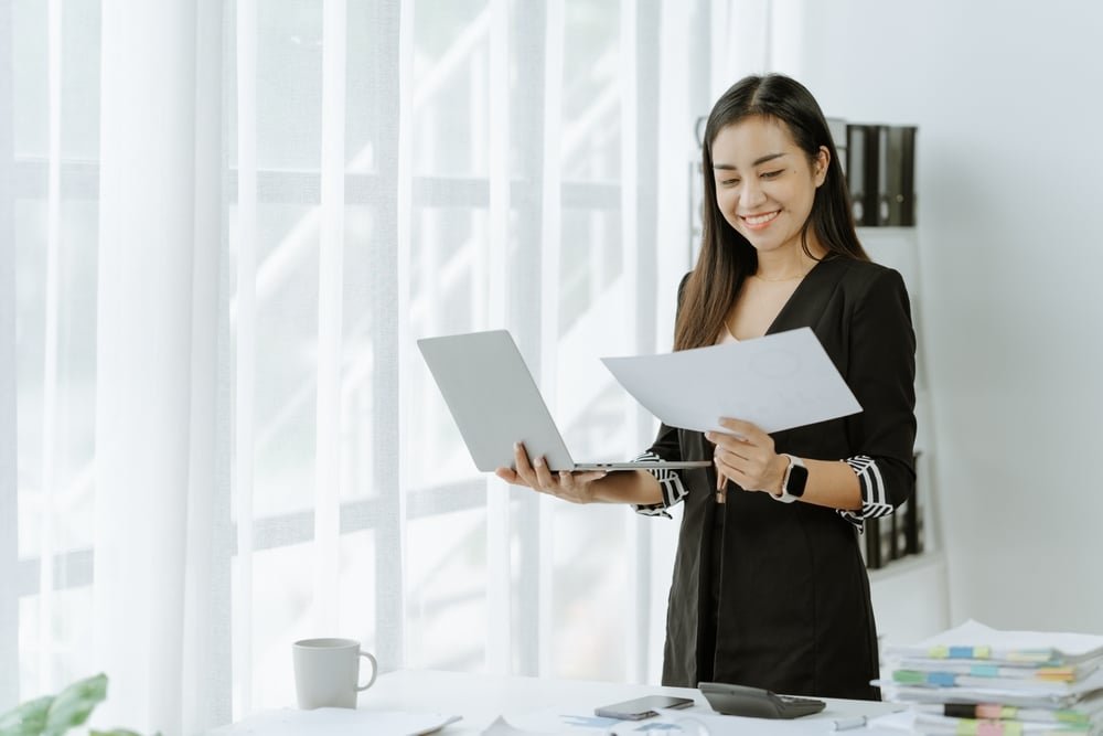 Asian,Woman,Sitting,At,A,Desk,Working,In,The,Office