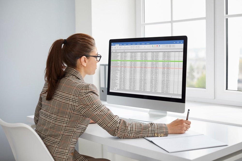 Young,Woman,Accountant,Working,With,Spreadsheet,On,Computer,Screen,In