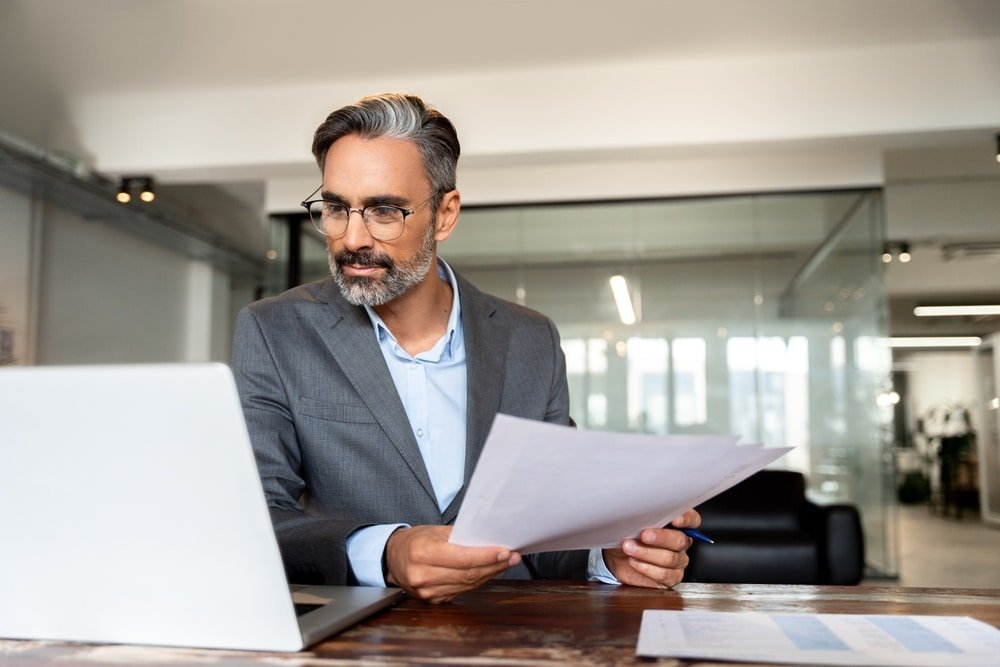 Focused,Hispanic,Businessman,With,Paperwork,In,Office.,Busy,Latin,Or