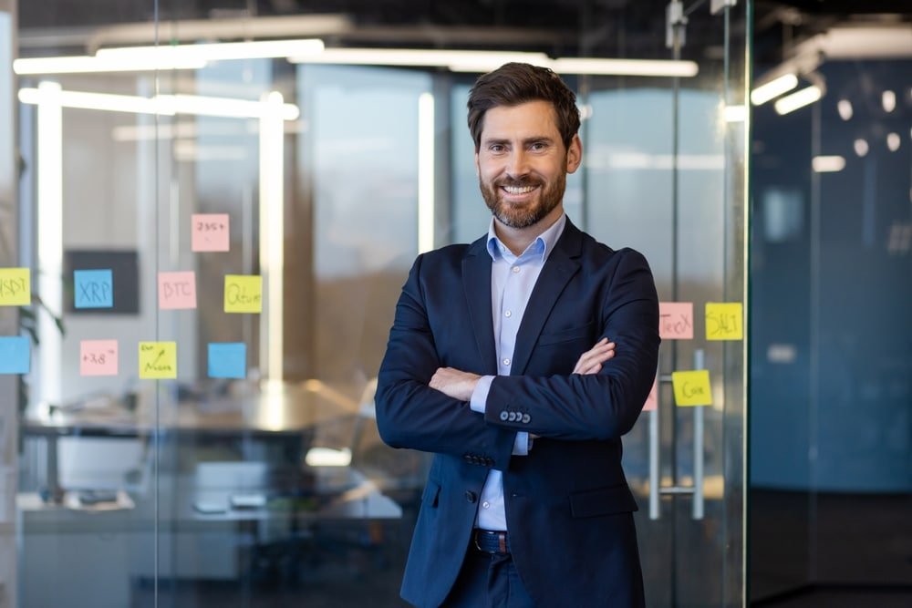 Portrait,Of,Successful,Businessman,Inside,Office,In,Business,Suit,,Man